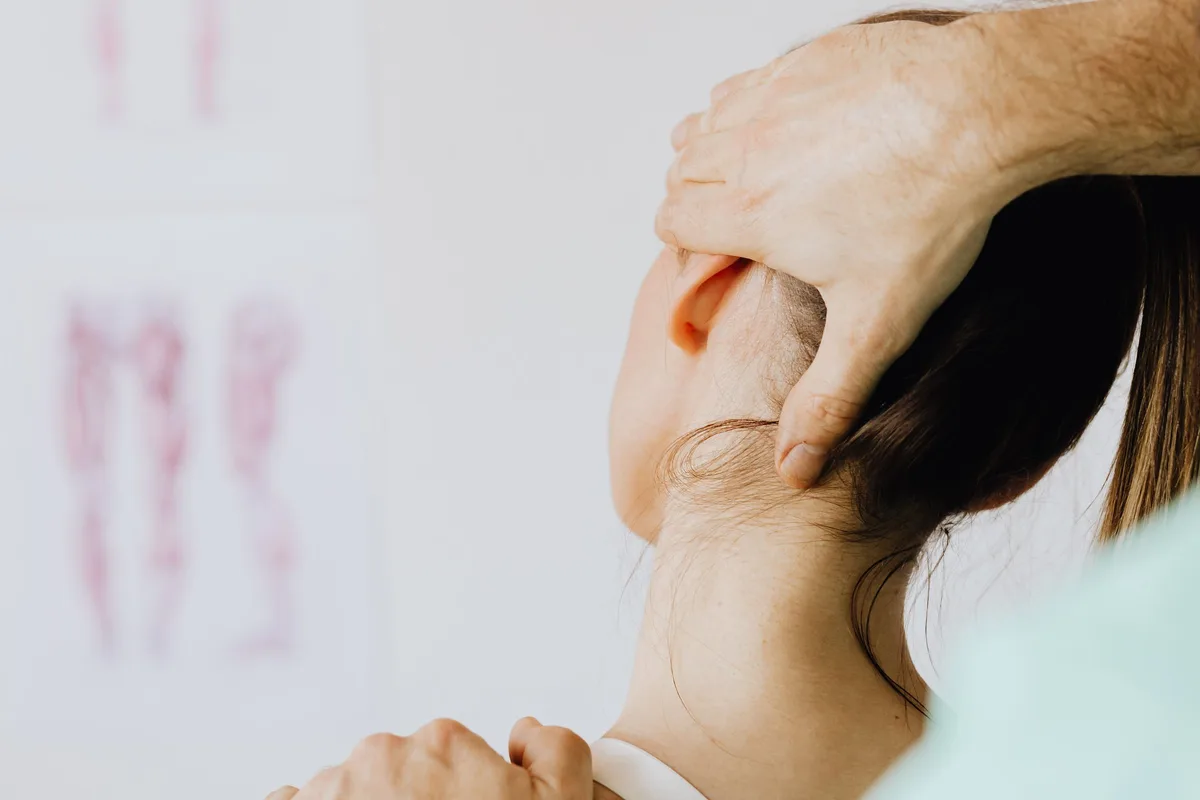 Chiropractor assessing a patient's neck and upper back in a Greenville, SC clinic