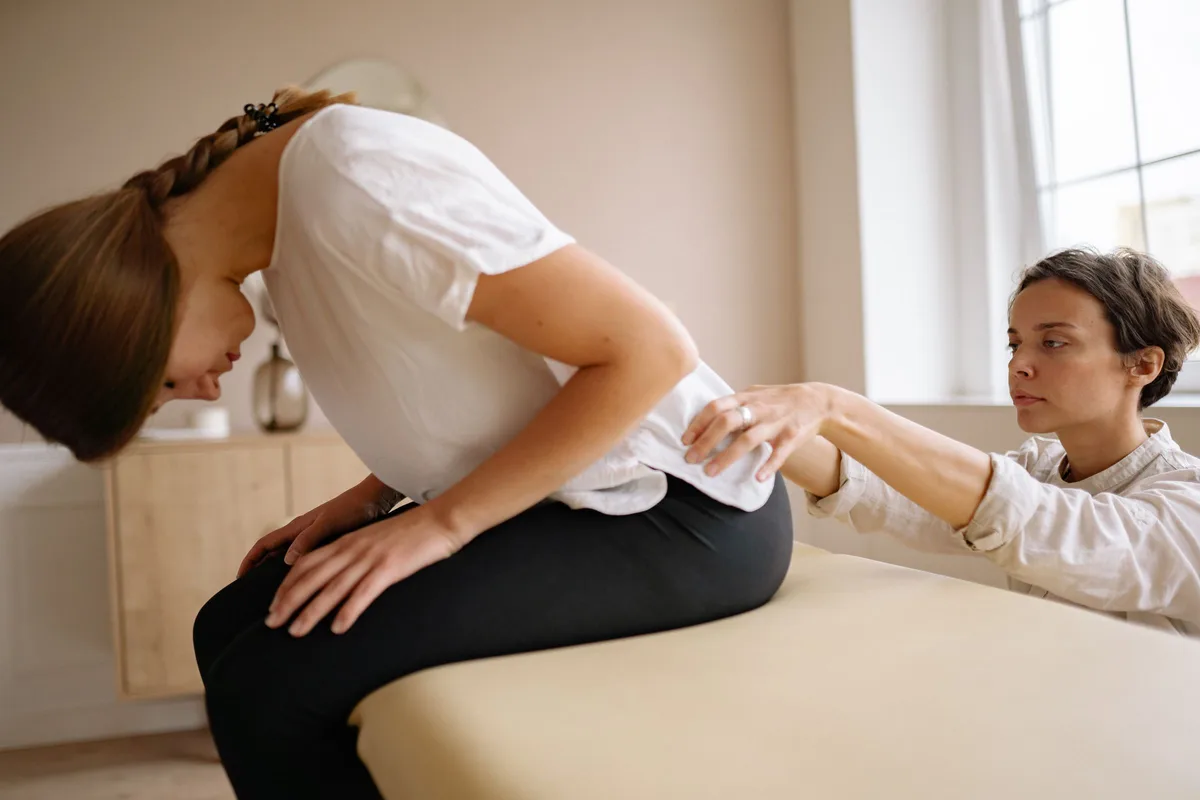 Chiropractor assessing a patient's lower back and hip in a Greenville, SC clinic