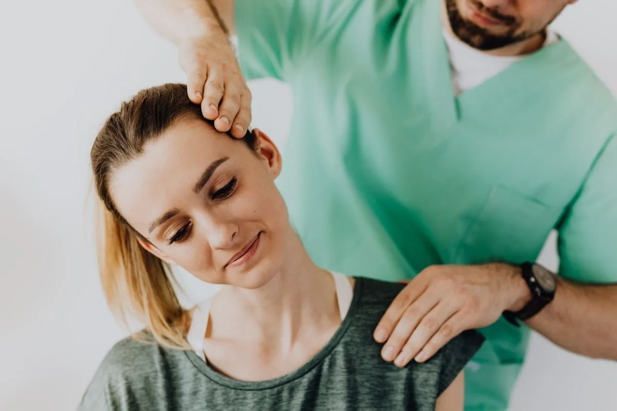 Chiropractor treating a patient's neck and jaw in a Greenville, SC clinic
